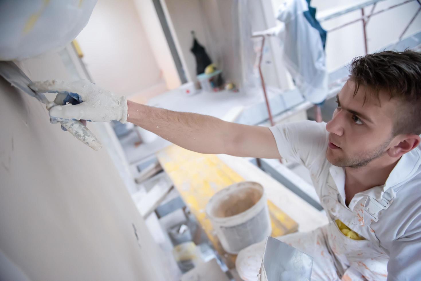 construction worker plastering on gypsum walls photo