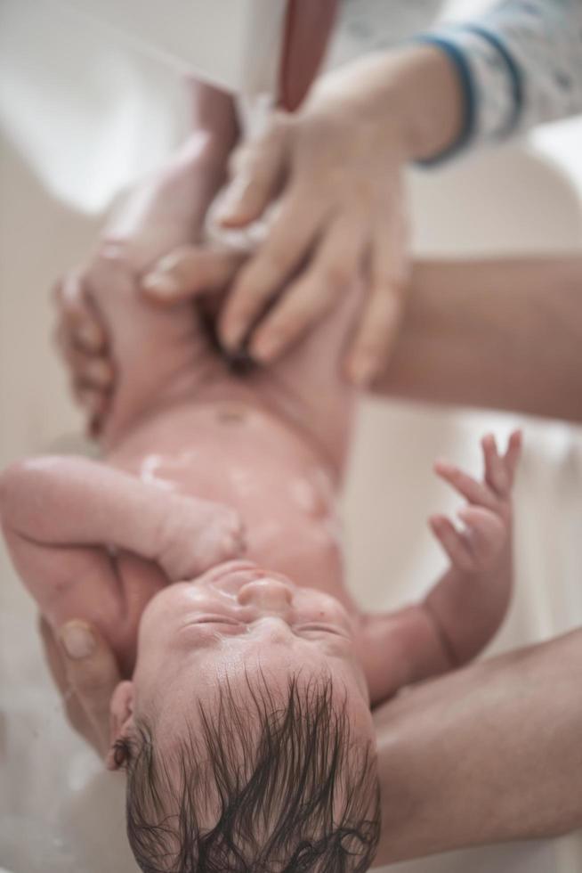 Newborn baby girl taking a  bath photo