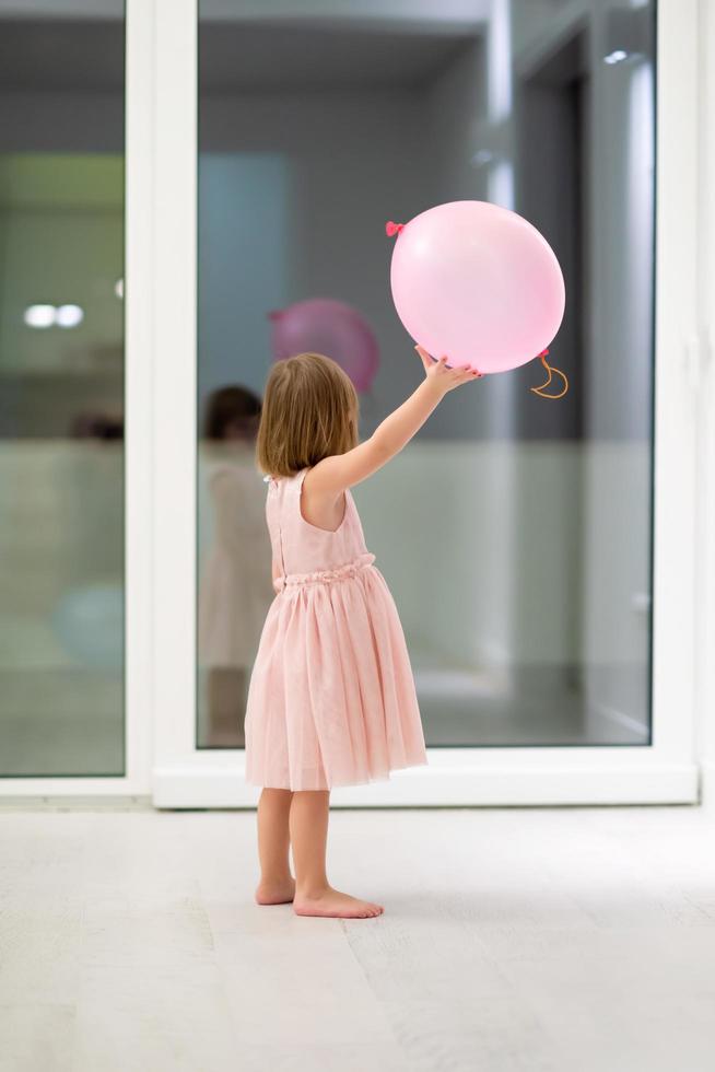 cute little girl playing with balloons photo