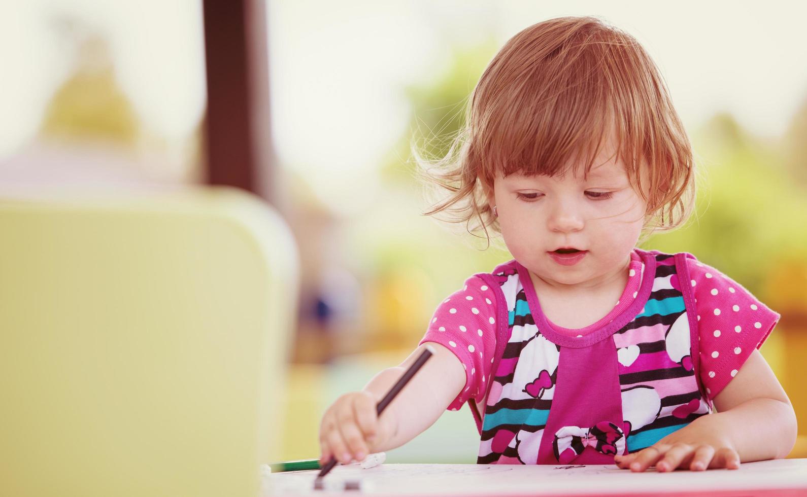 little girl drawing a colorful pictures photo