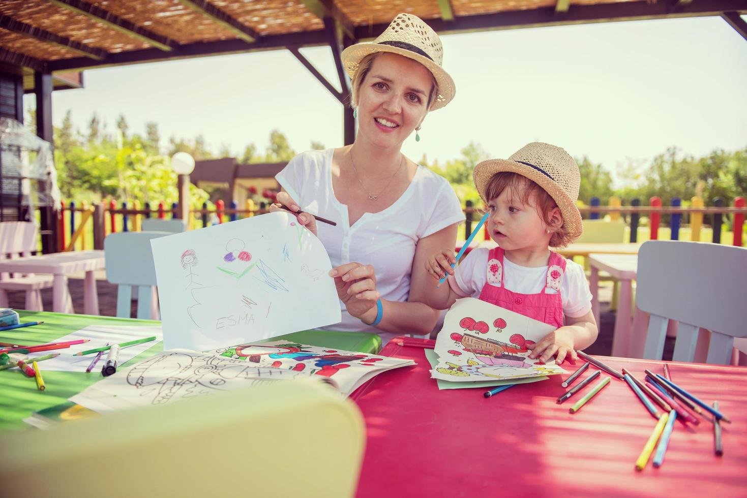 mom and little daughter drawing a colorful pictures photo