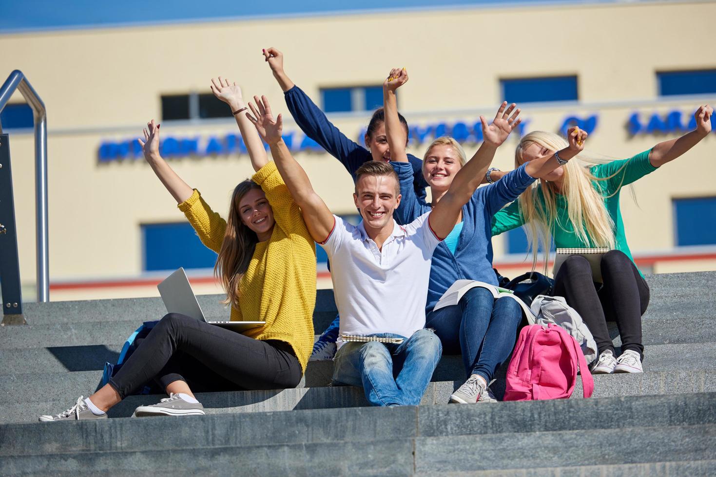 students outside sitting on steps photo