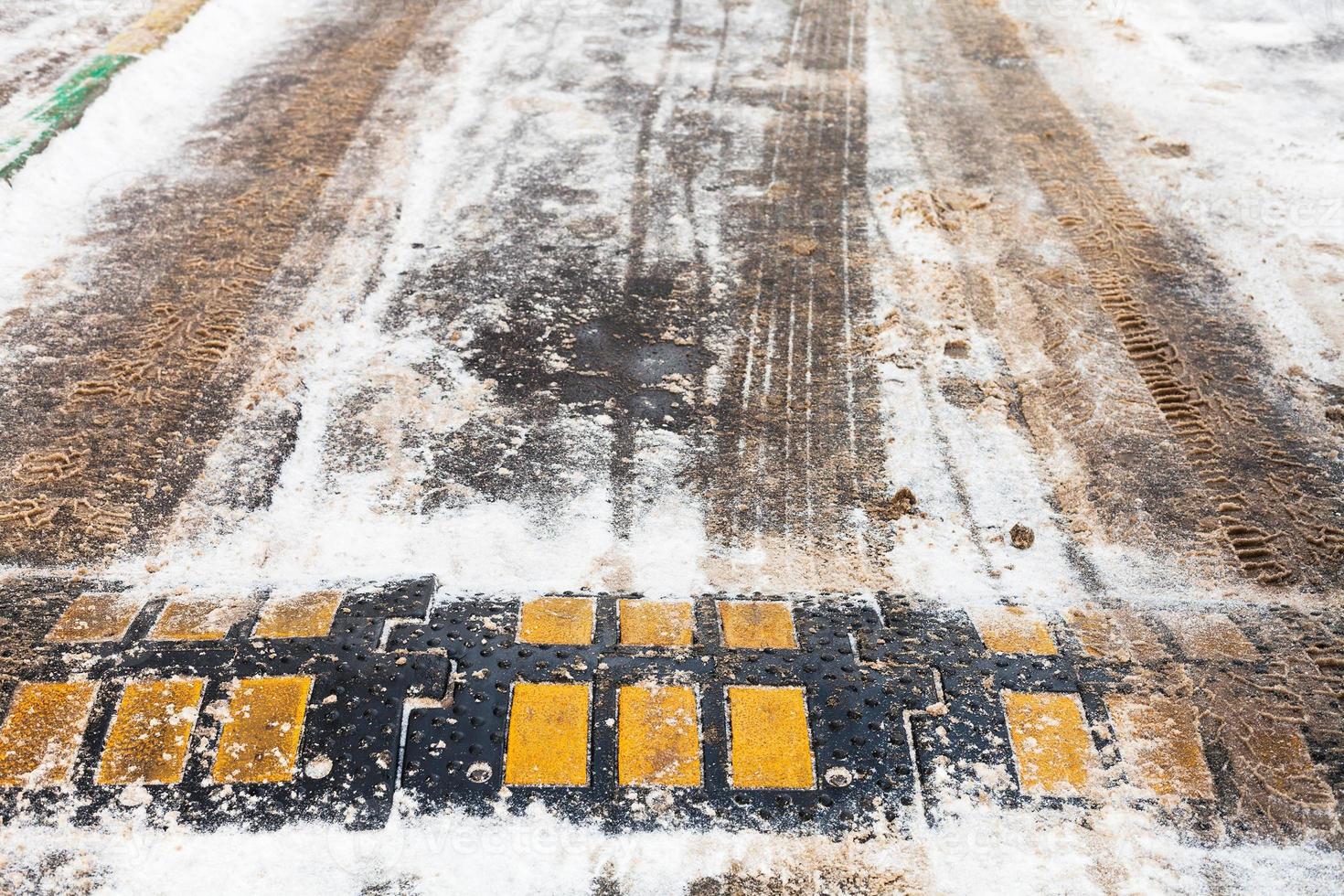 speed bump in snow on urban road in winter photo