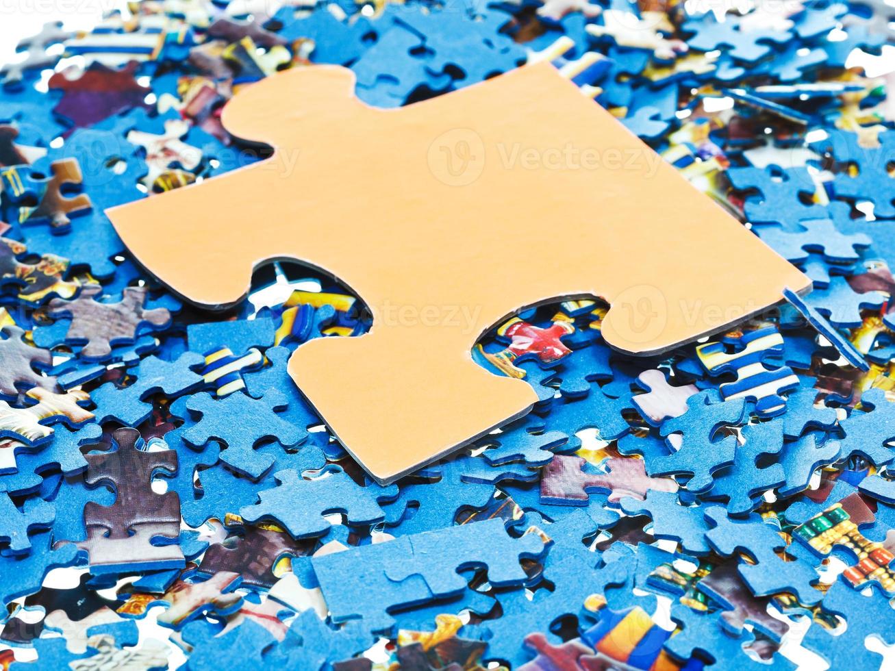 big piece on pile of disassembled puzzles photo