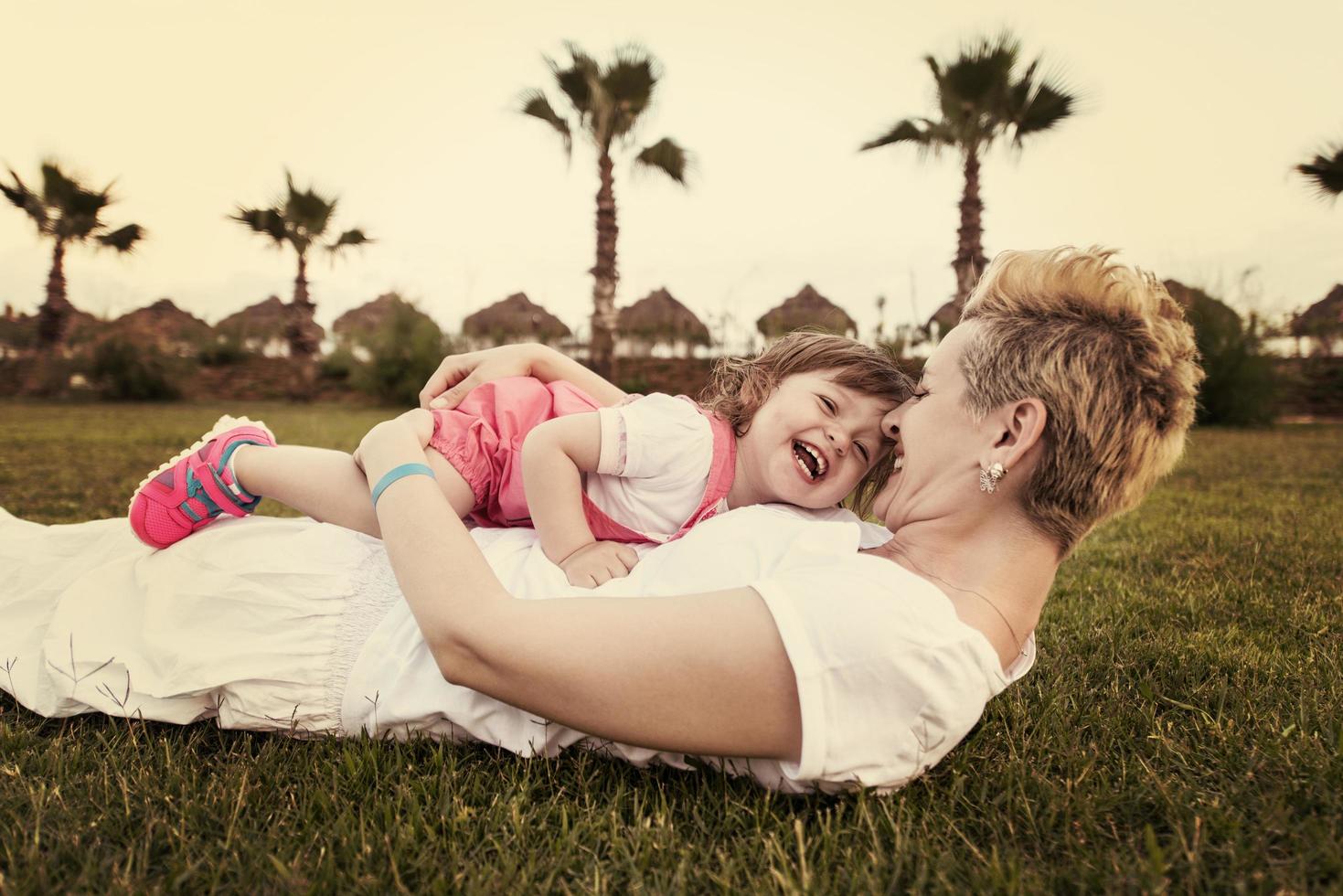 mother and little daughter playing at backyard photo