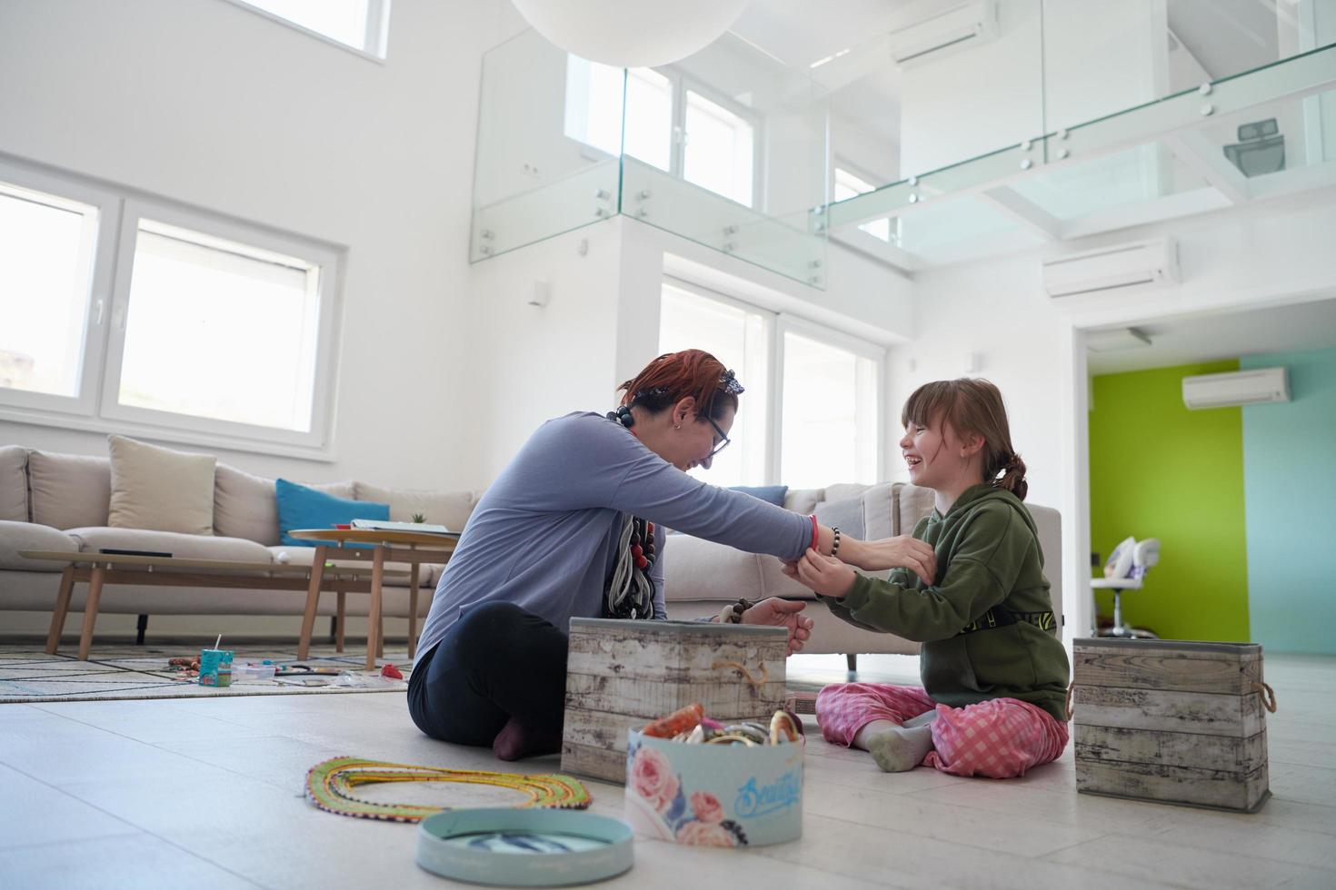 madre e hija pequeña jugando con joyas en casa foto