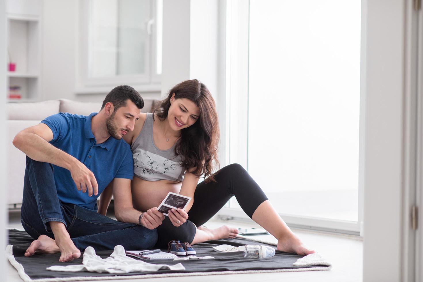 pregnant couple checking a list of things for their unborn baby photo