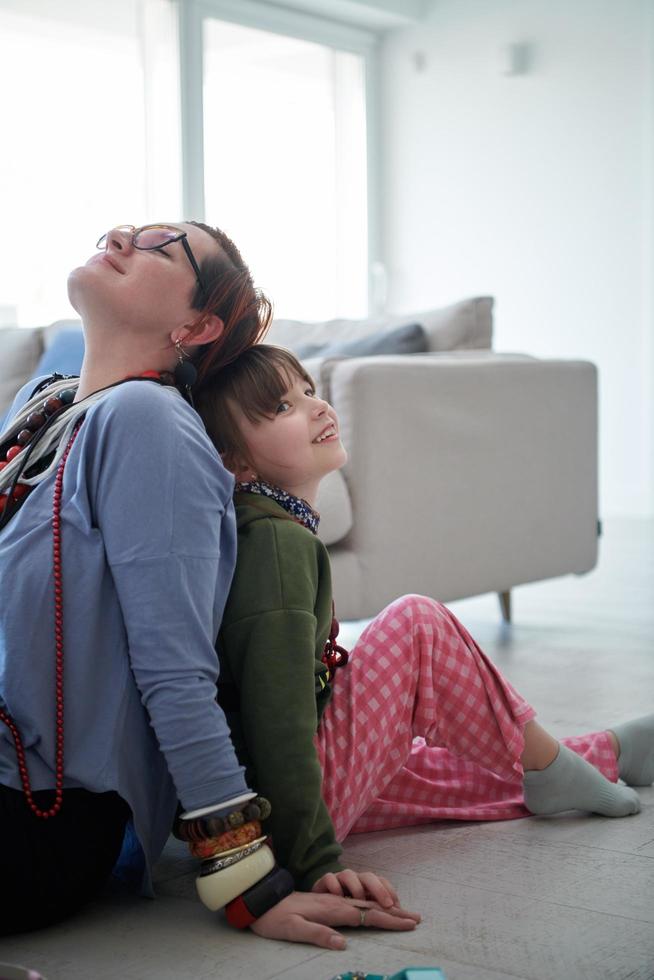 madre e hija pequeña jugando con joyas en casa foto