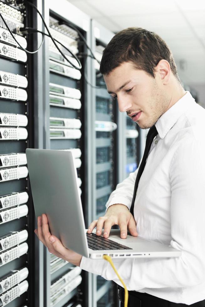 businessman with laptop in network server room photo