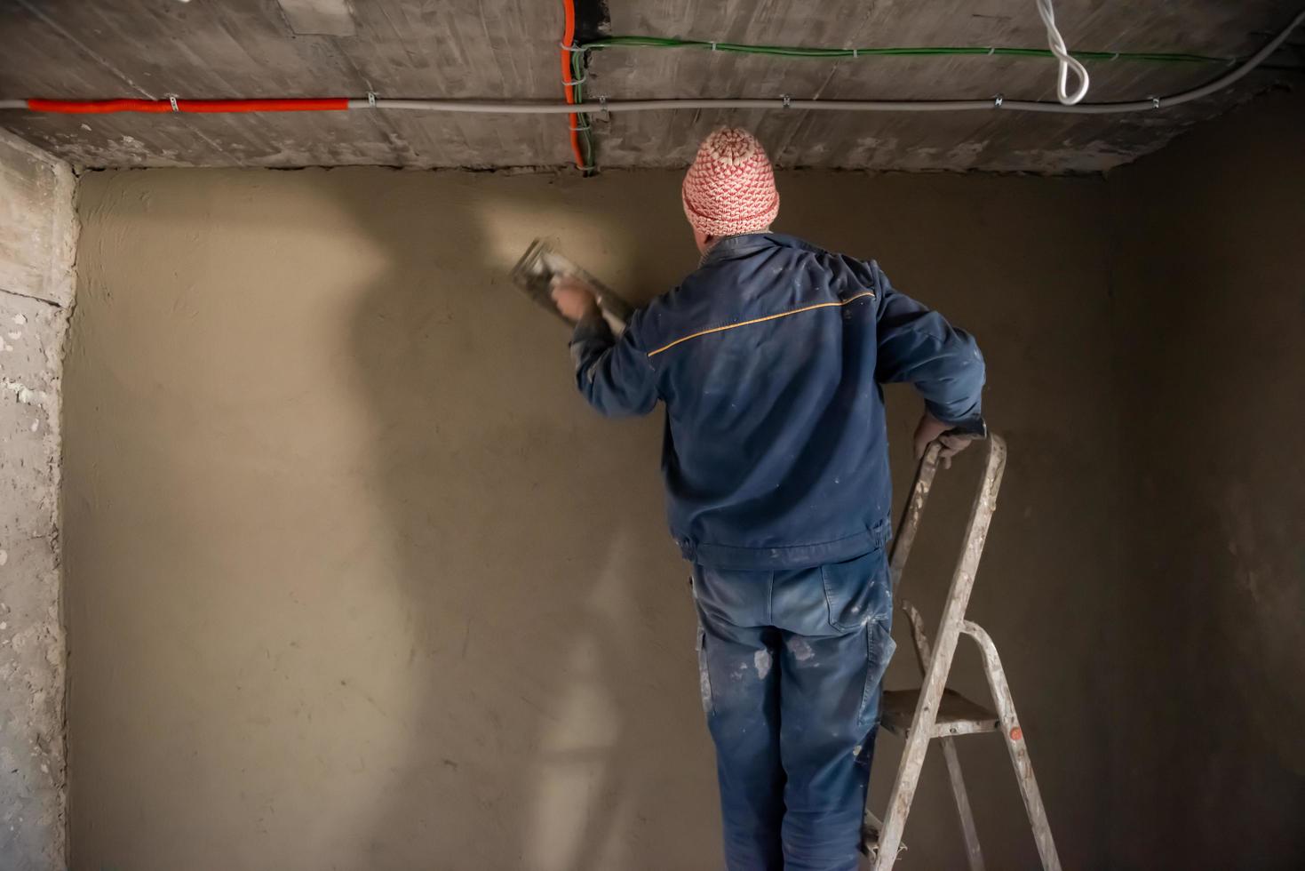 Worker plastering the wall by concrete photo
