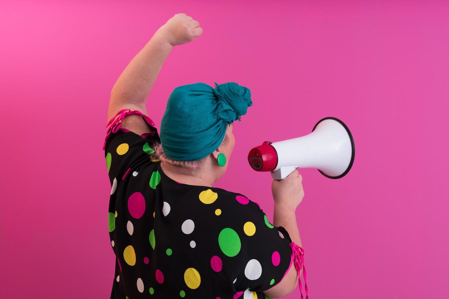 Funny plus size woman woman girl posing isolated on pastel pink wall background studio portrait. People sincere emotions lifestyle concept. Mock up copy space. Screaming in megaphone. photo