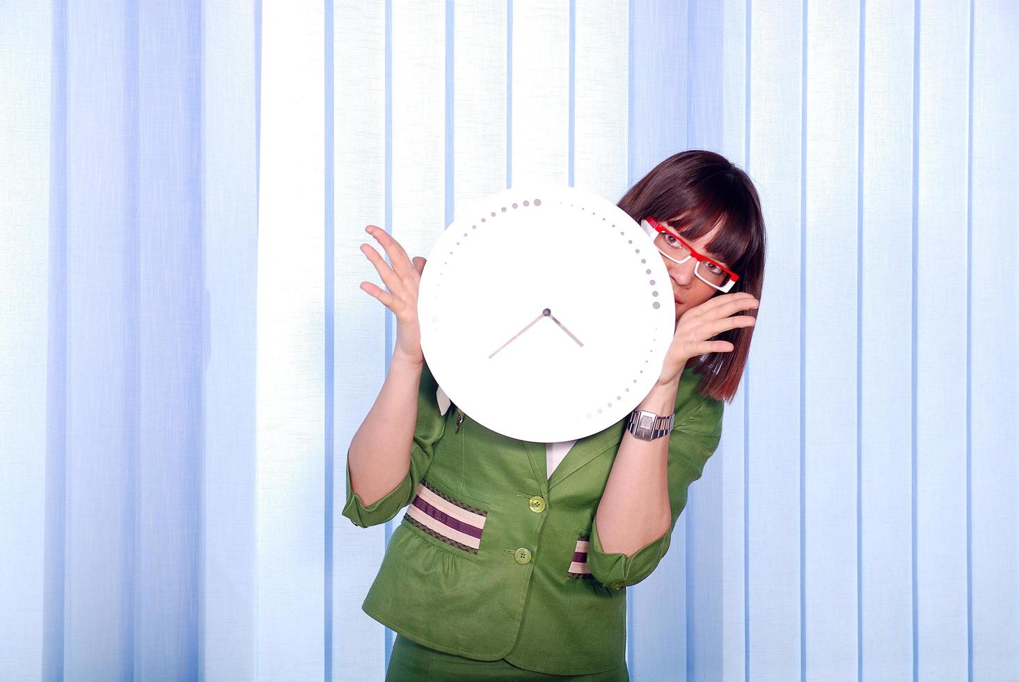 .a pretty business woman hiding behind a clock photo