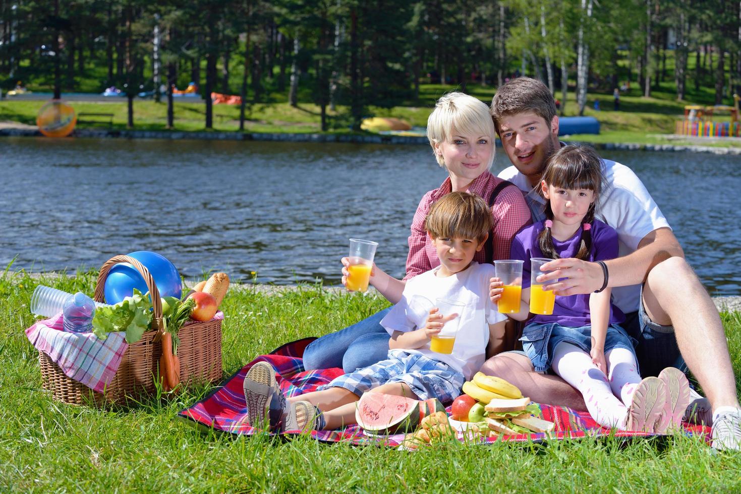 Happy family playing together in a picnic outdoors photo