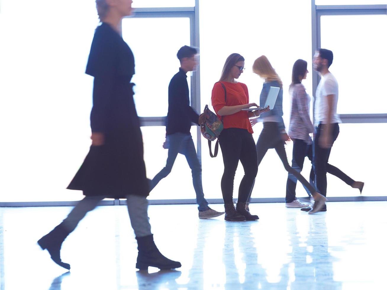 student girl standing with laptop, people group passing by photo