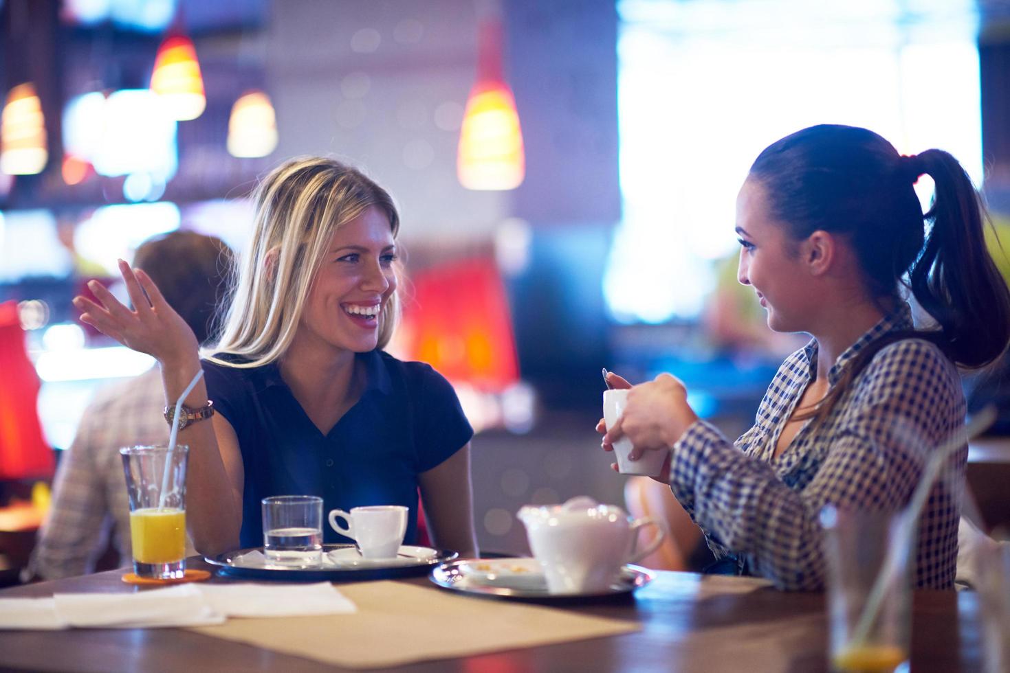 las chicas toman una taza de café en el restaurante foto