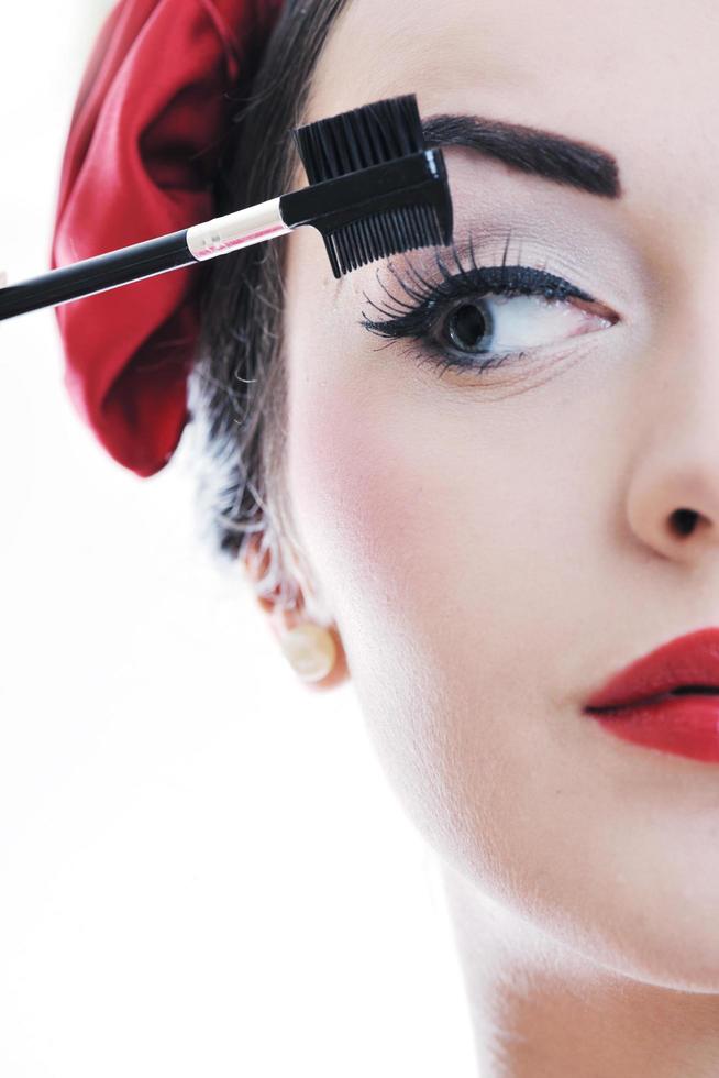 beautiful young woman applying makeup photo