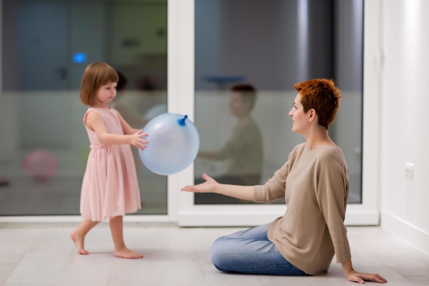 mother and cute little daughter playing with balloons photo