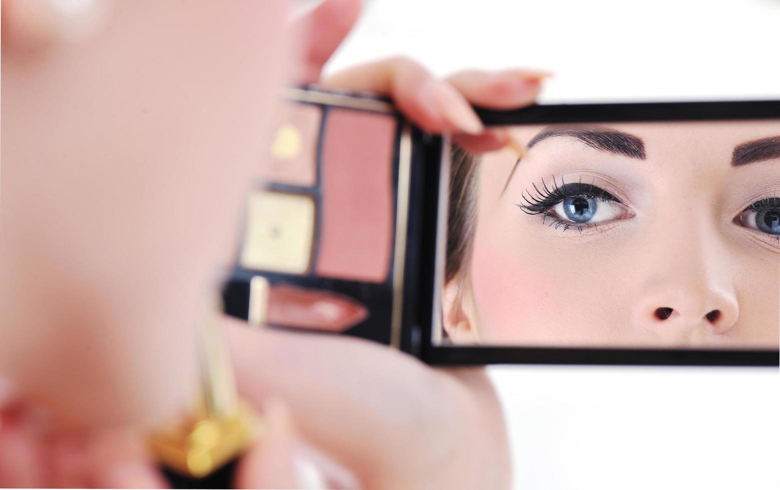 hermosa joven aplicando maquillaje foto