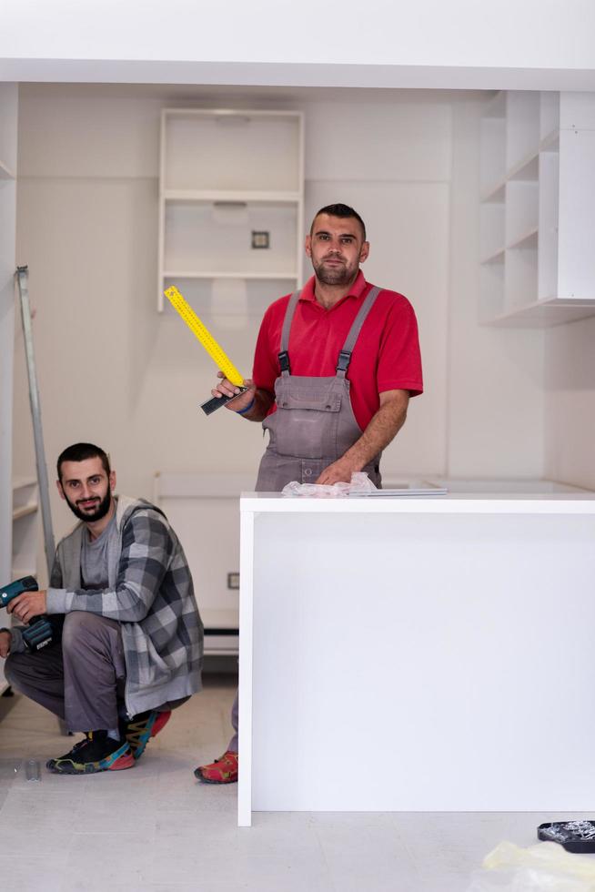 jóvenes trabajadores instalando una nueva cocina foto