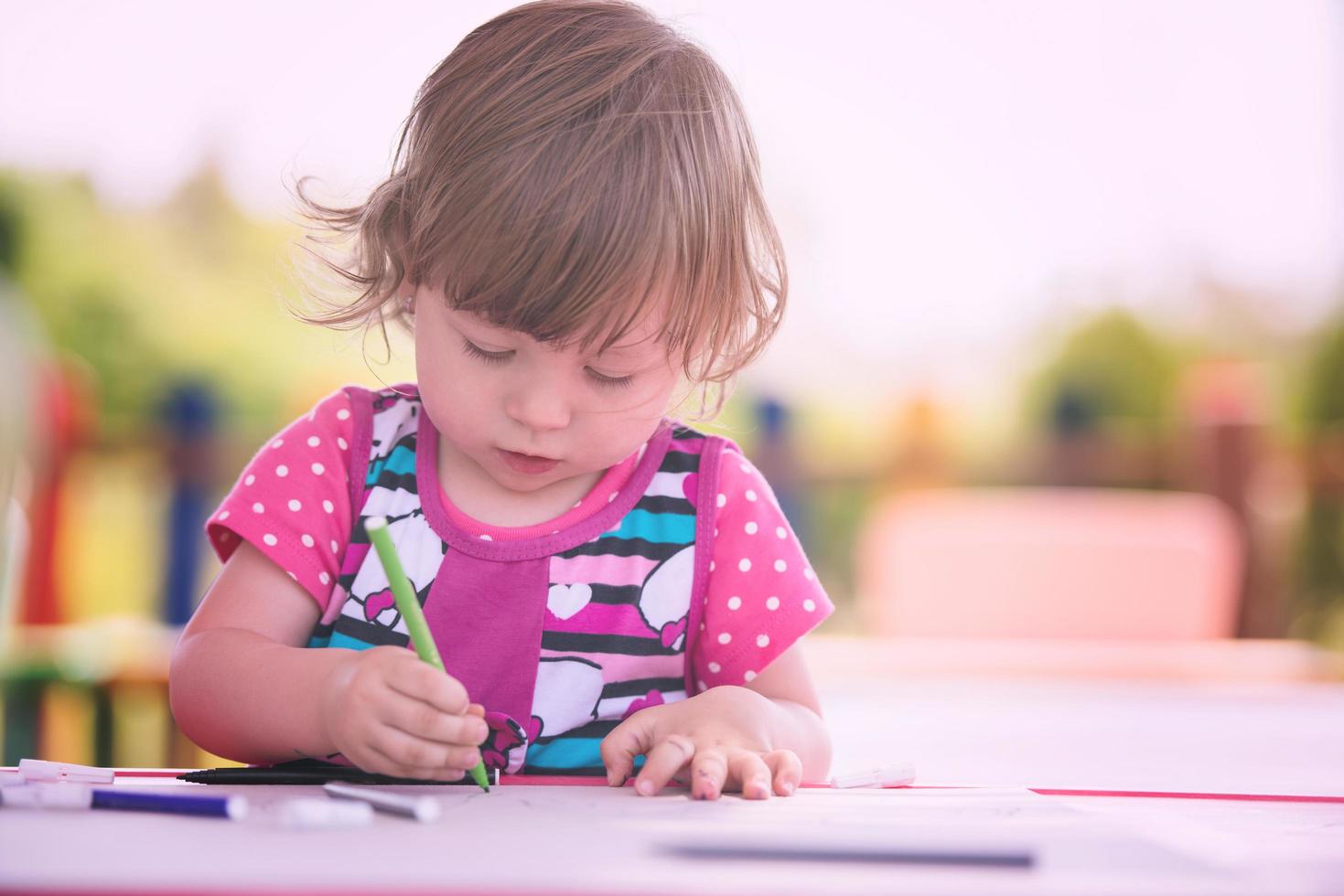 little girl drawing a colorful pictures photo