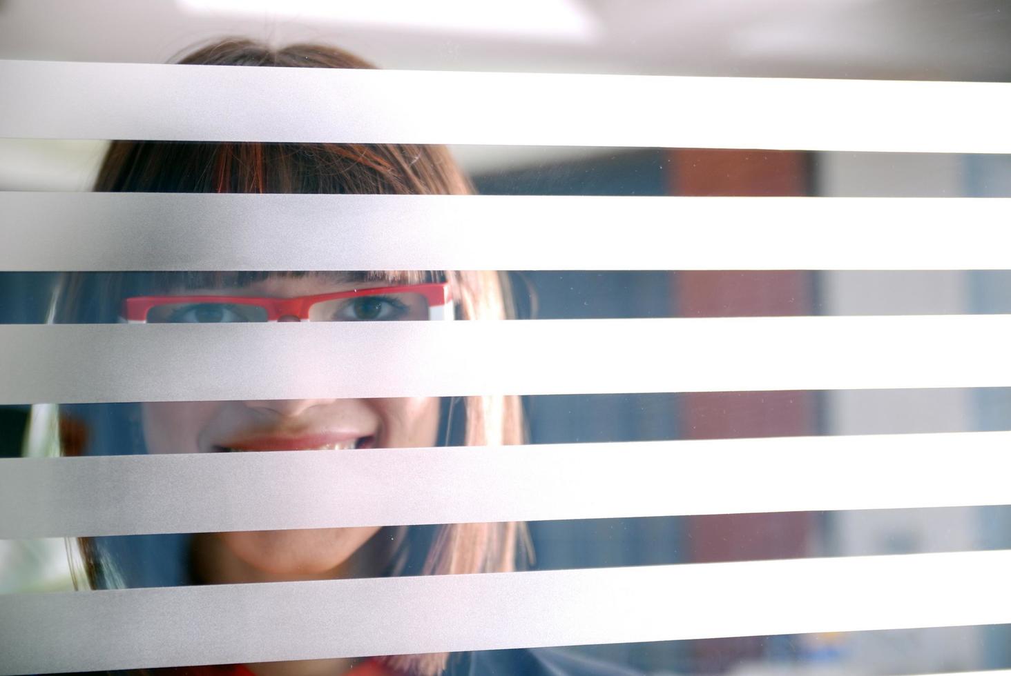 joven empresaria mirando a través de una pared transparente foto