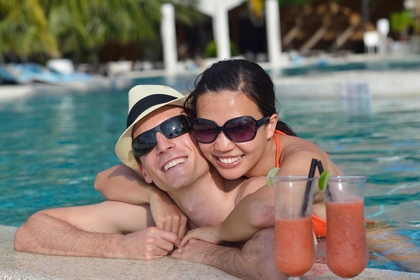 happy young couple relax and take fresh drink on poolside photo