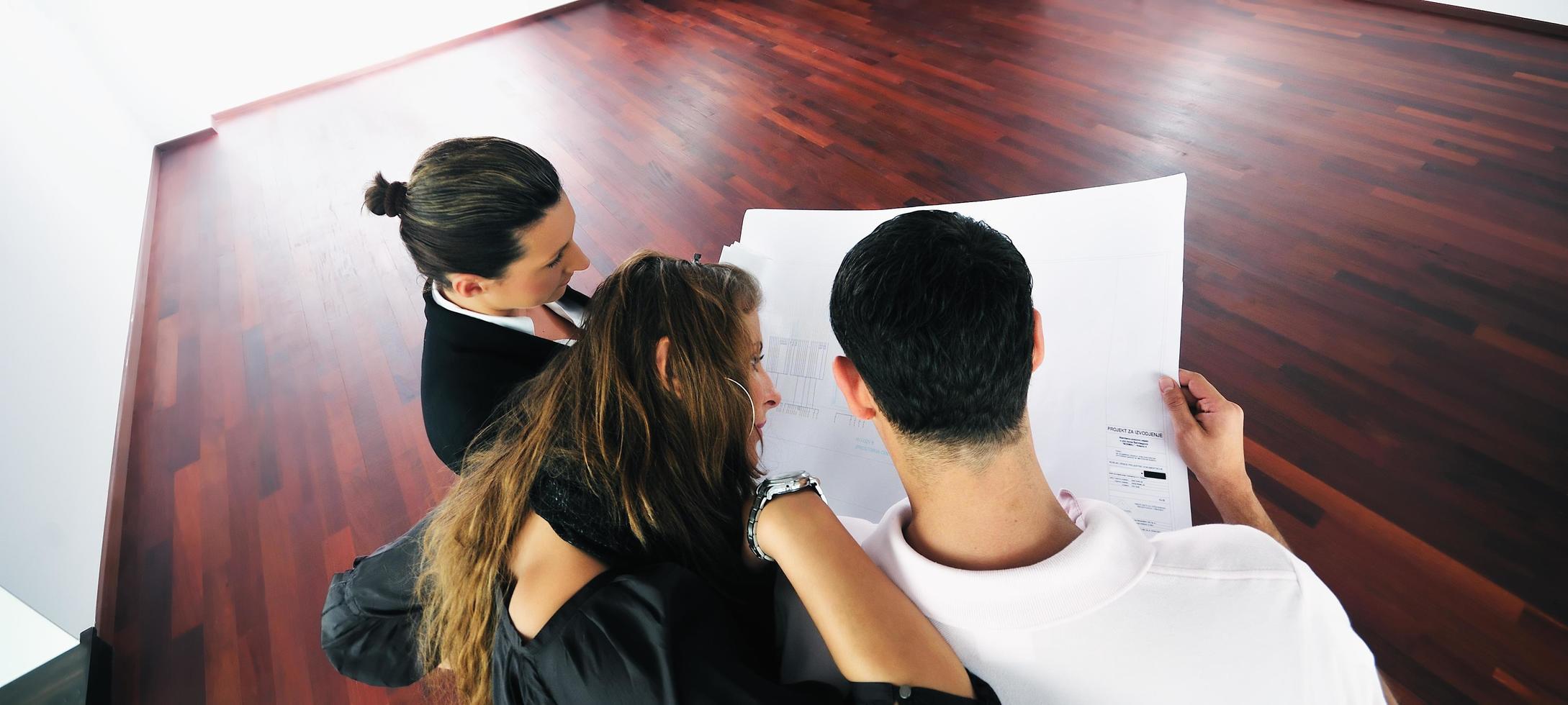 happy young couple buying new home with real estate agent photo