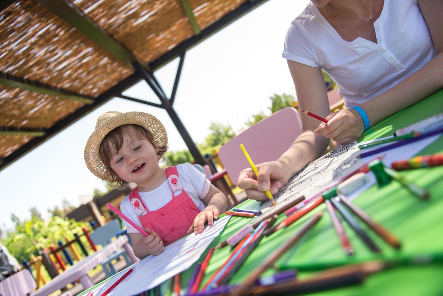 mamá y su pequeña hija dibujando imágenes coloridas foto