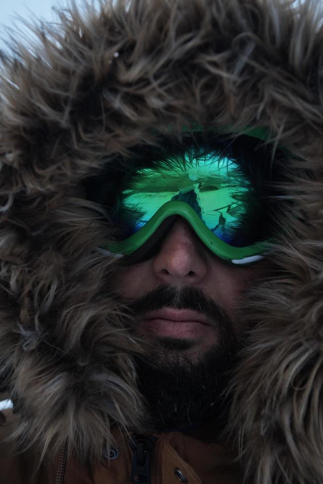 man at winter in stormy weather wearing warm  fur jacket photo