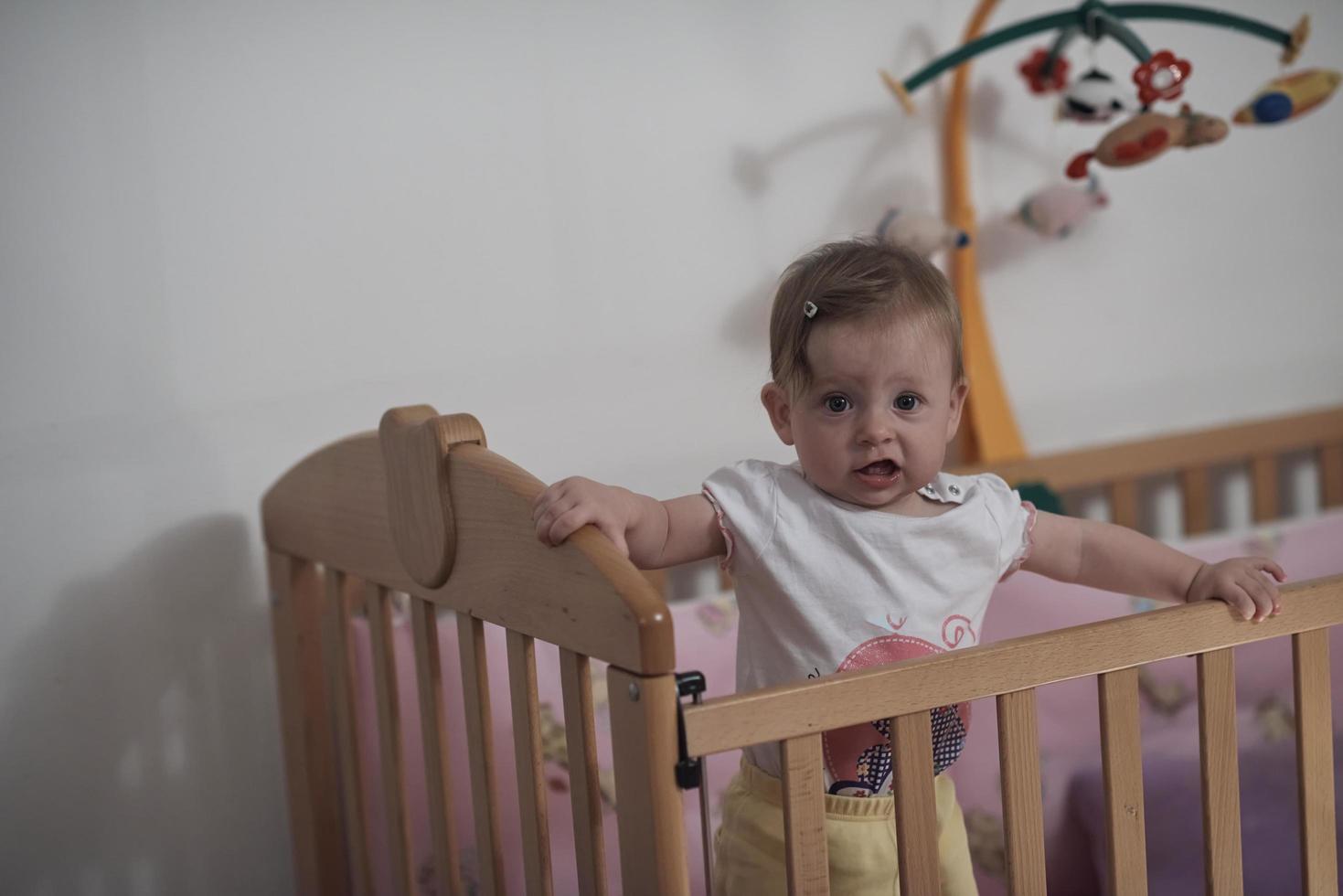 cute  little one year old baby and making first steps in bed photo