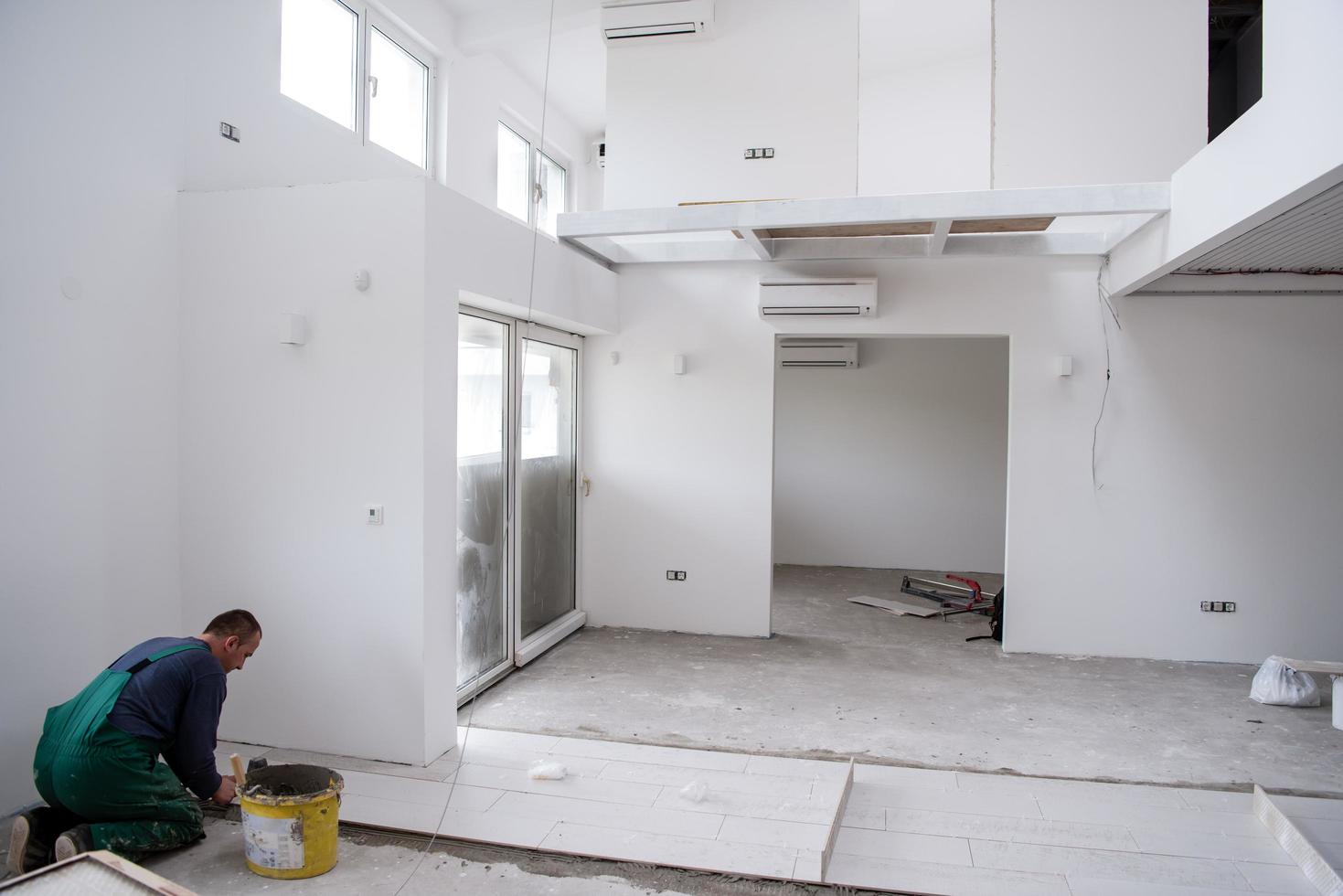 worker installing the ceramic wood effect tiles on the floor photo