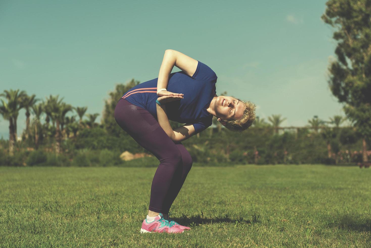 female runner warming up and stretching photo