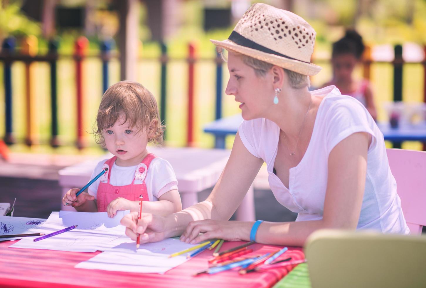 mamá y su pequeña hija dibujando imágenes coloridas foto