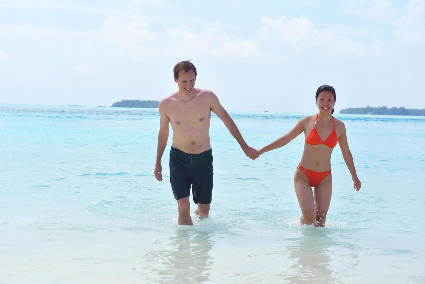 happy young couple have fun on beach photo