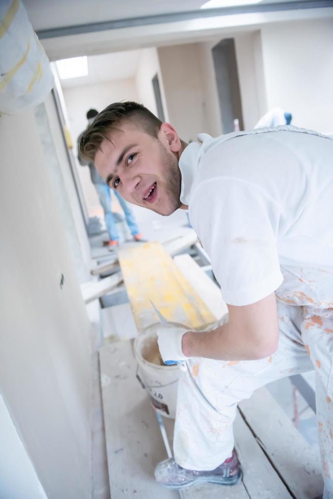 construction worker plastering on gypsum walls photo