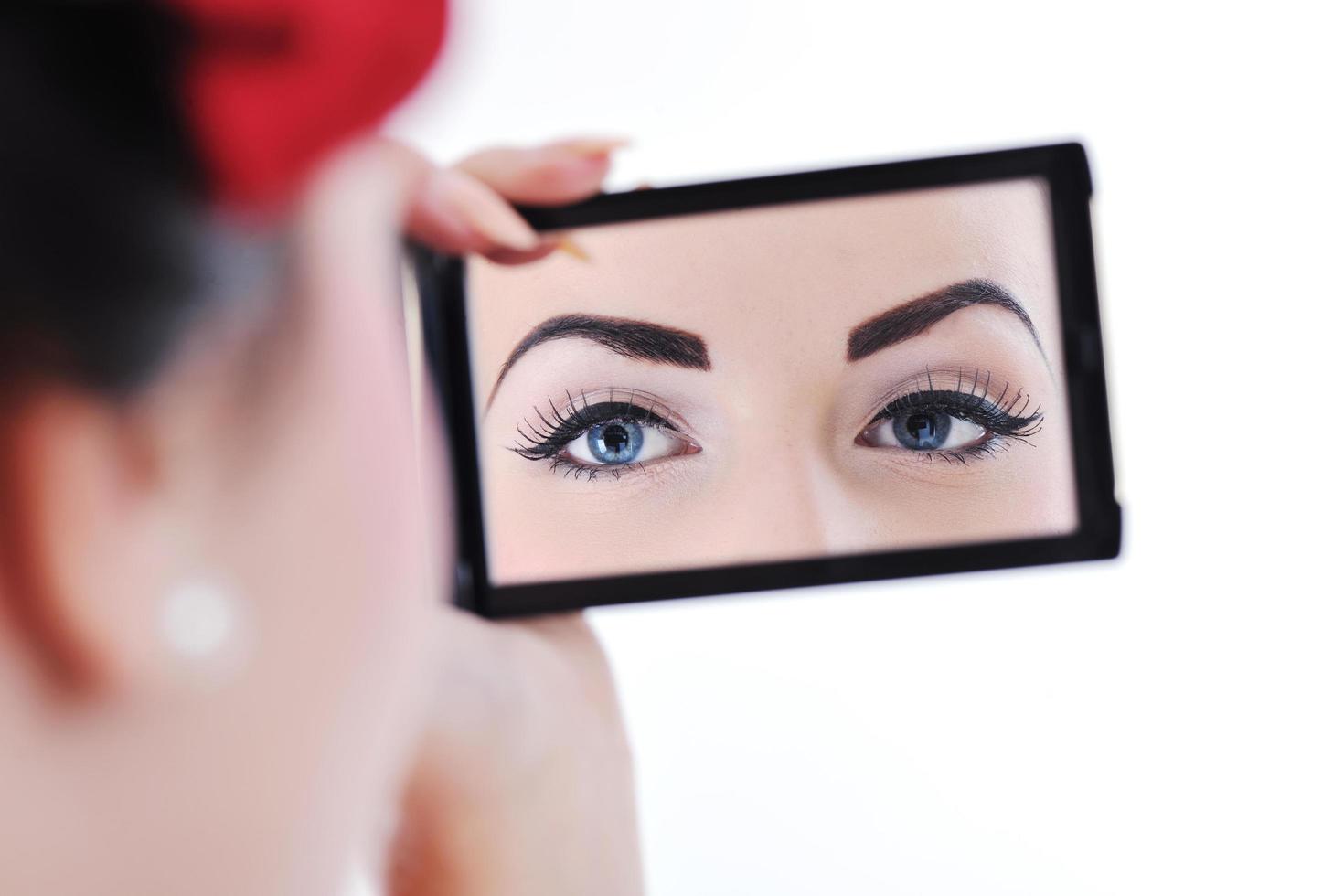 beautiful young woman applying makeup photo