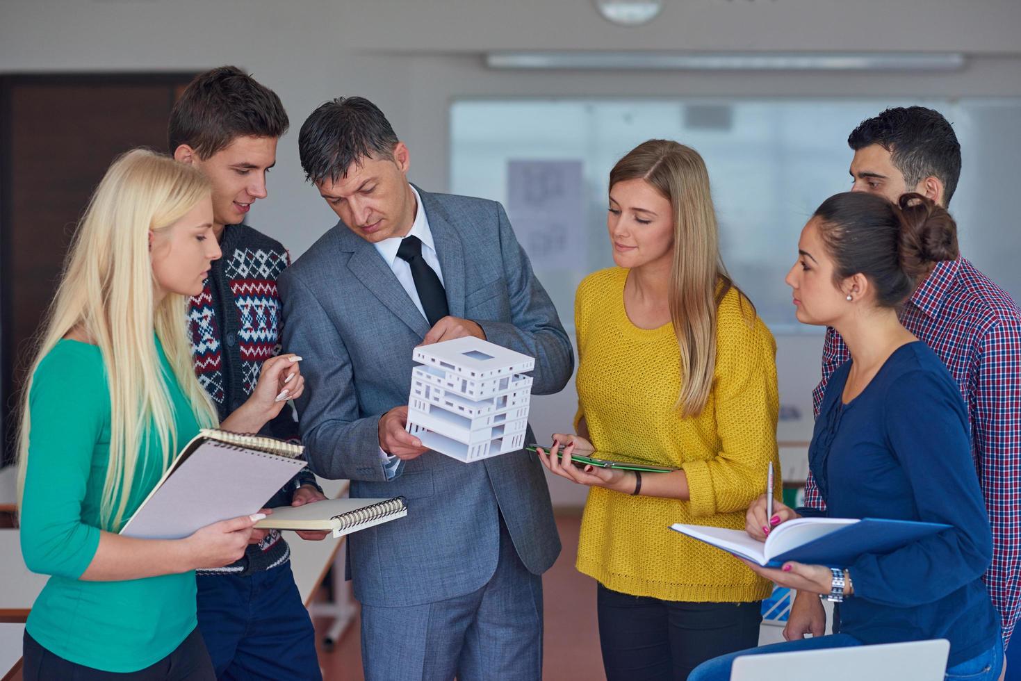 group of students working with teacher on  house model photo