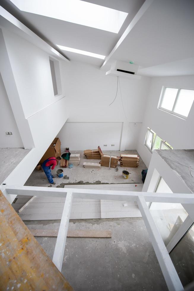 worker installing the ceramic wood effect tiles on the floor photo