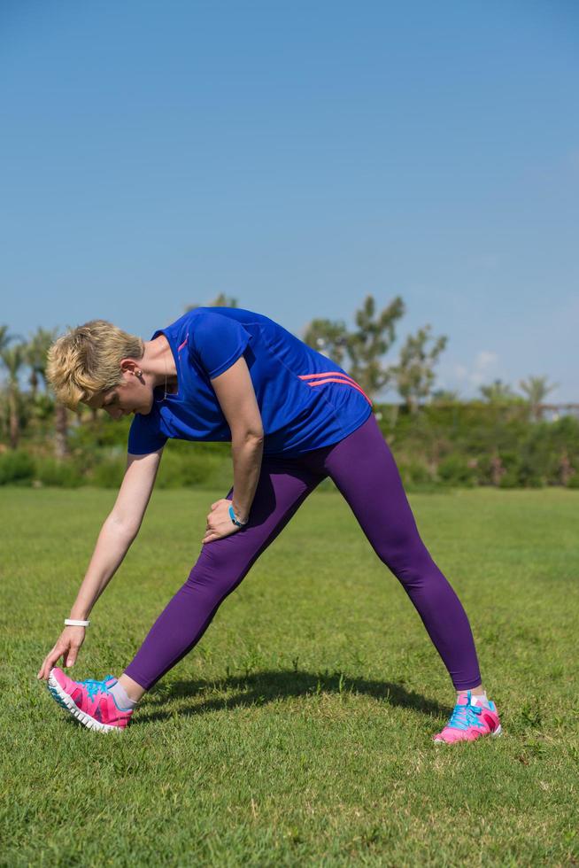 female runner warming up and stretching photo
