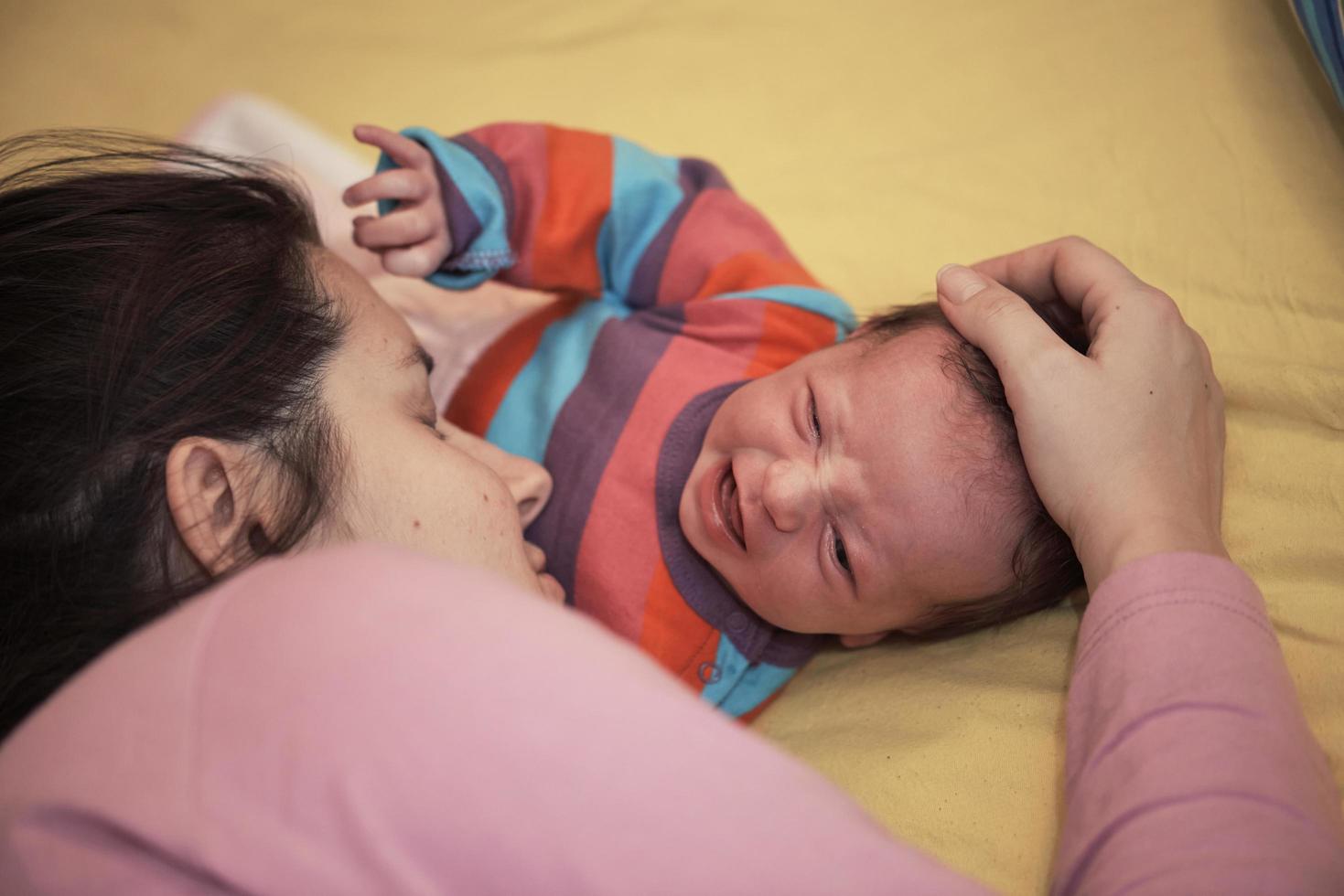 la madre está jugando con el bebé en casa foto