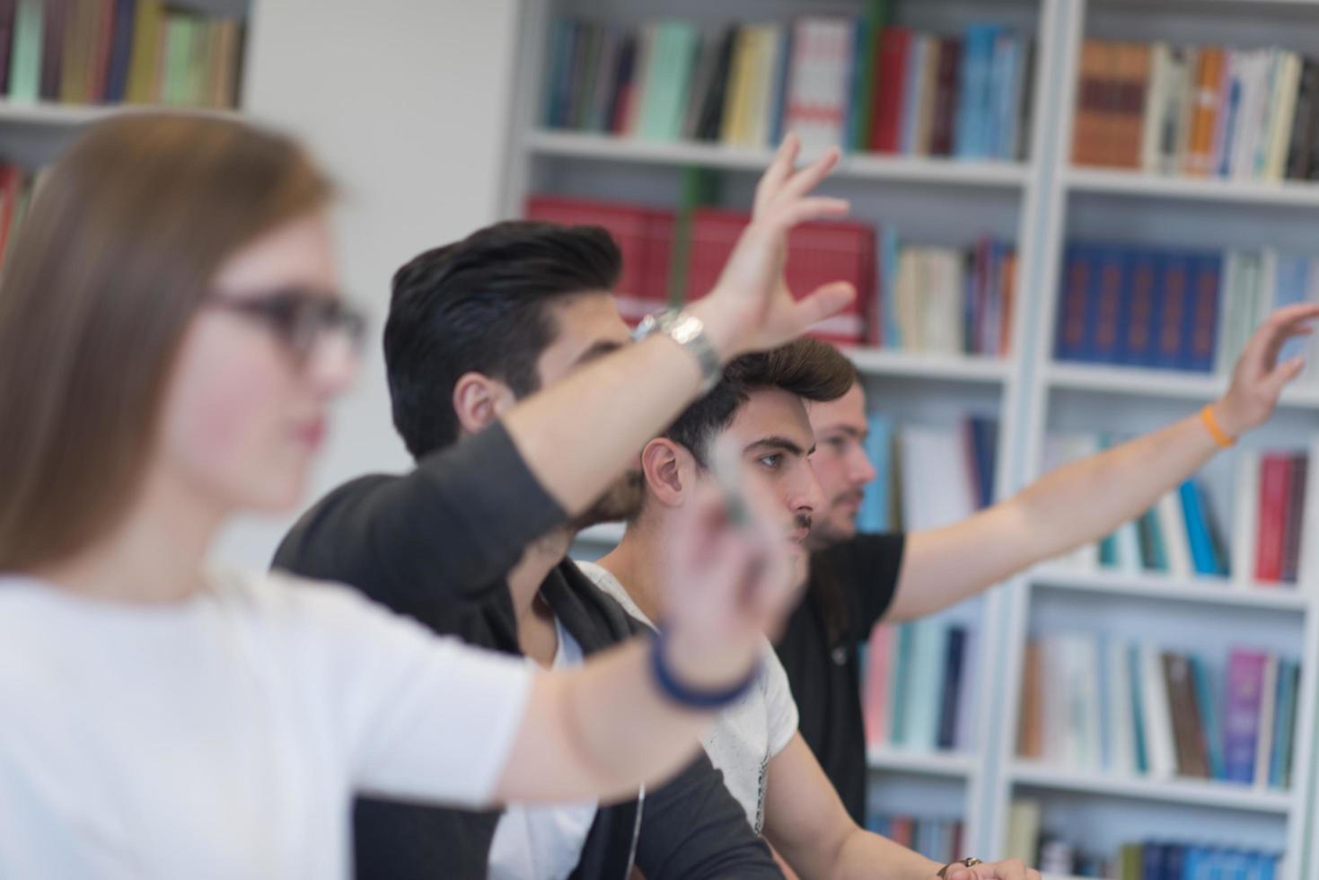 grupo de estudiantes levantan la mano foto