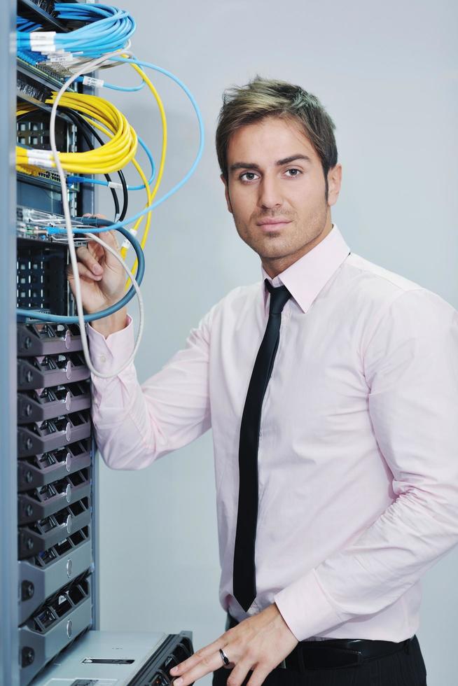 young it engineer in datacenter server room photo