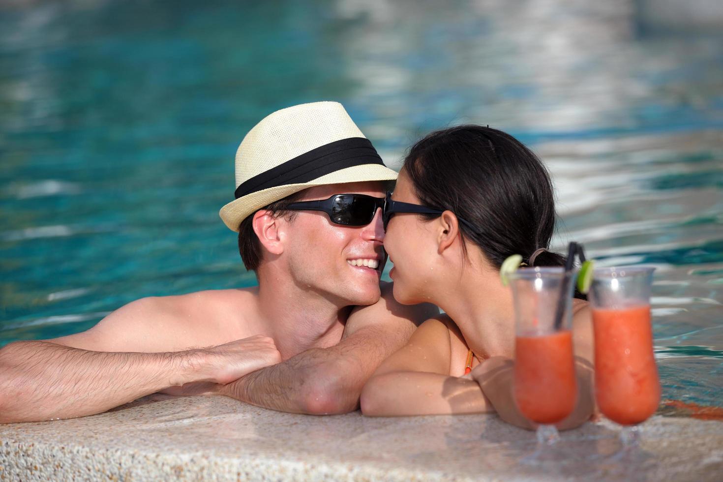 happy young couple relax and take fresh drink on poolside photo