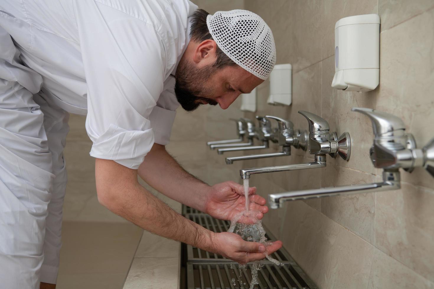 A Muslim takes ablution for prayer. Islamic religious rite photo