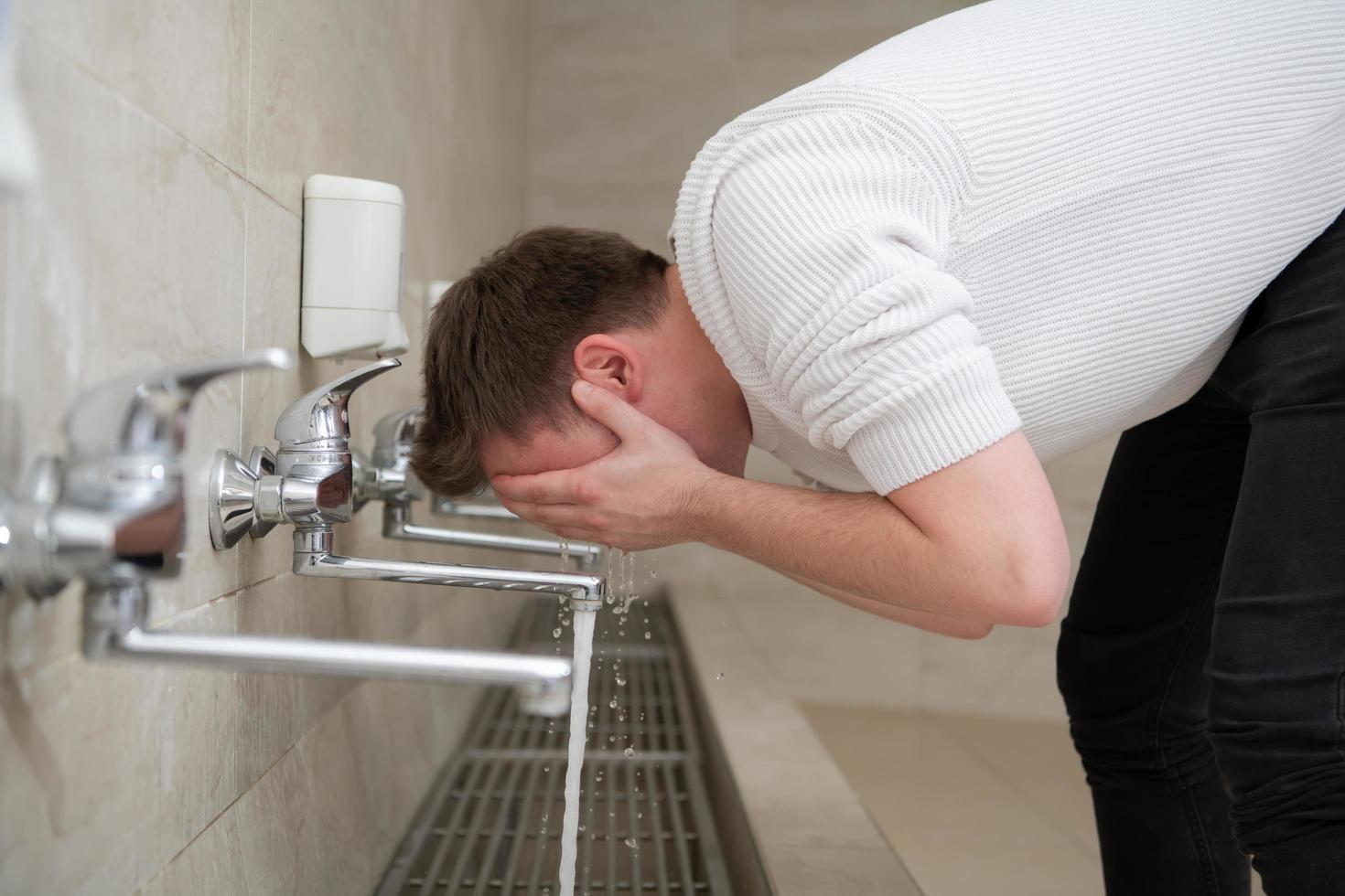 A Muslim takes ablution for prayer. Islamic religious rite photo