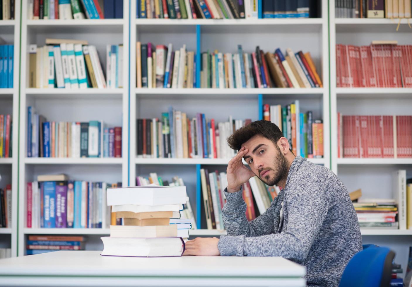 portrait of student while reading book  in school library photo