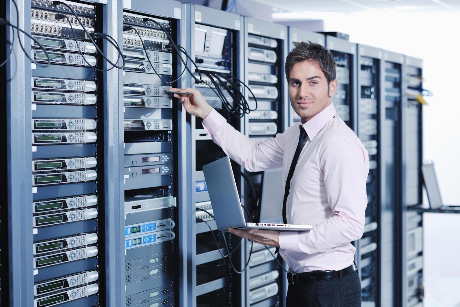 businessman with laptop in network server room photo