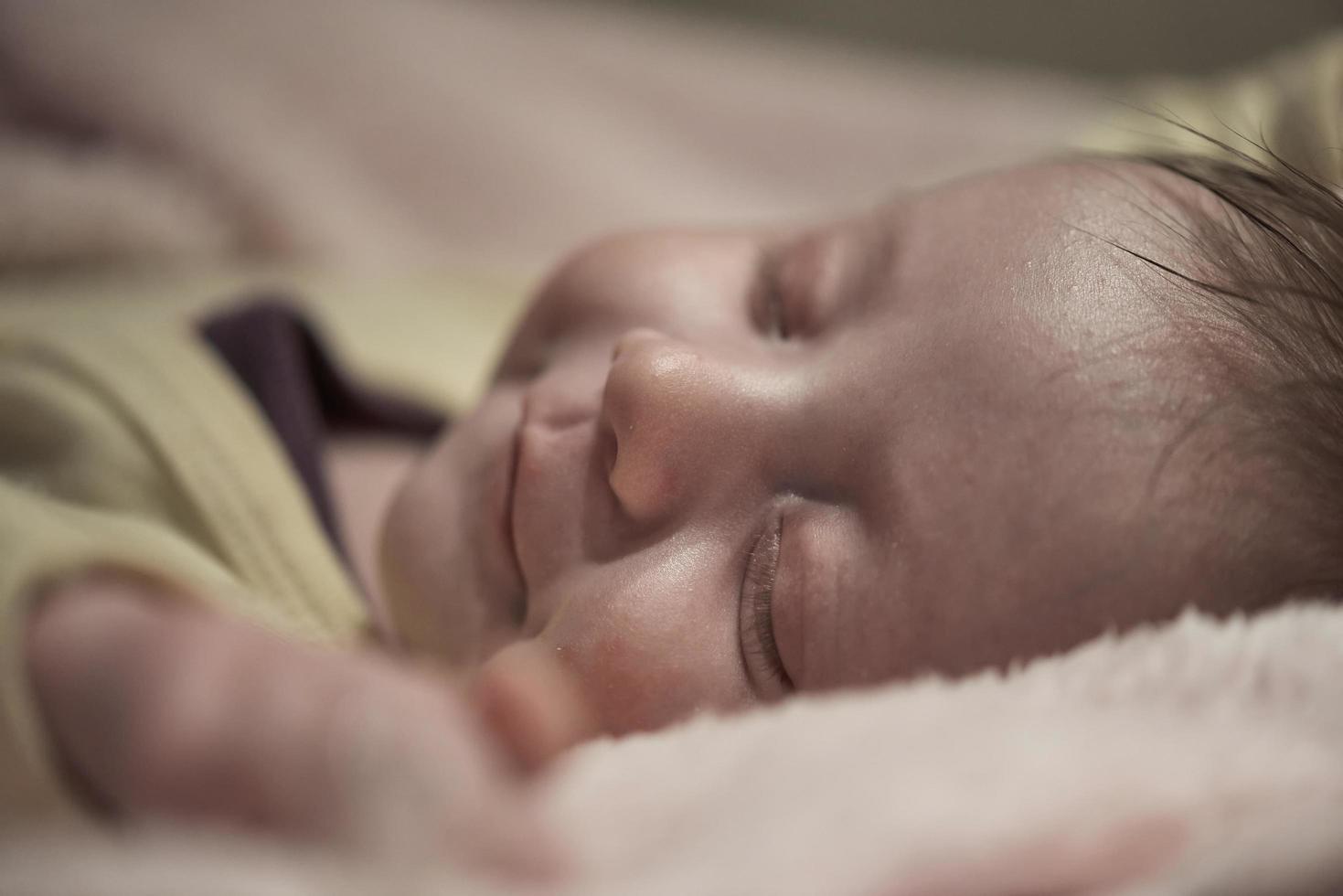 bebé recién nacido durmiendo en casa en la cama foto