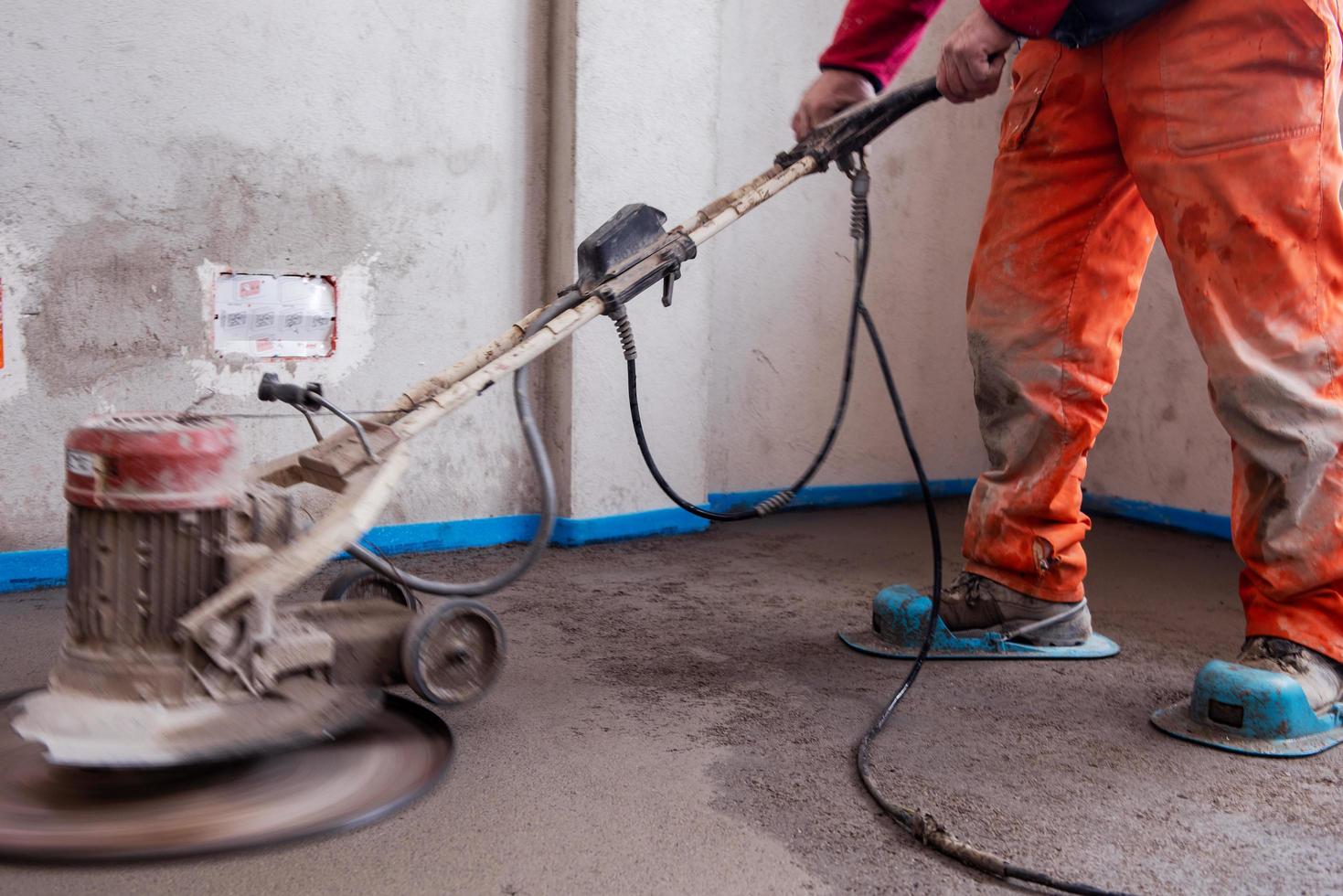 worker performing and polishing sand and cement screed floor photo