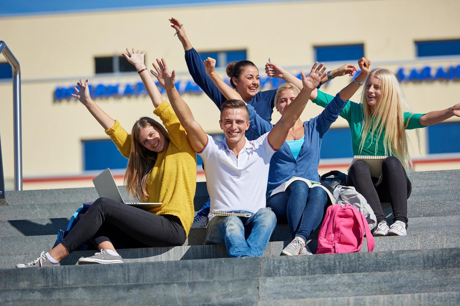 students outside sitting on steps photo